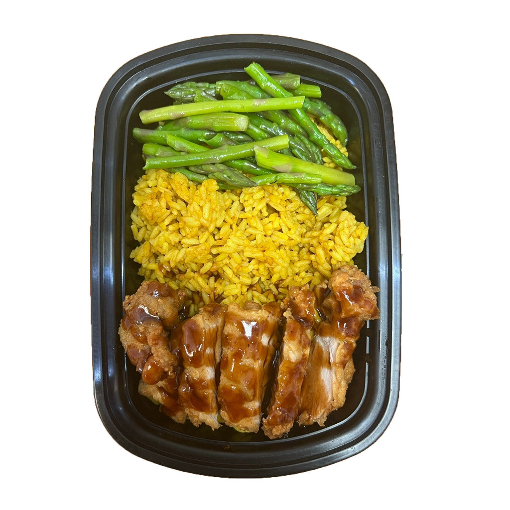 Crispy fried chicken served over a bed of fluffy yellow rice, paired with tender asparagus